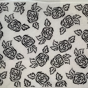 May include: A white sheet of paper with a repeating pattern of black stylized roses. The roses are outlined in black and have a swirling pattern.