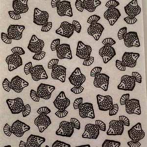 May include: A white background with a repeating pattern of black fish. The fish are stylized and have a simple design.