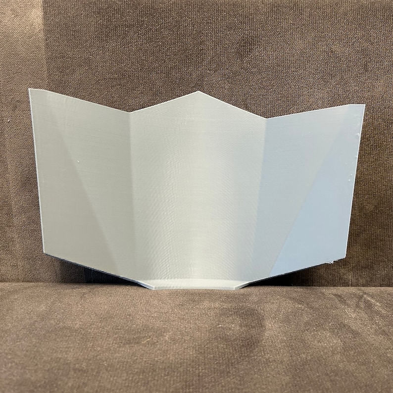 Pu&ograve; includere: Un design in carta piegata, geometrico, stampato in 3D, di colore bianco. Il design ha la forma di una stella a cinque punte.