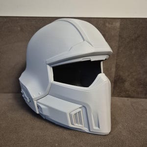 Op de afbeelding: Een set van drie keramische mokken met een gespikkelde, matte afwerking. De mokken zijn in crème, lichtgrijs en donkergrijs. Elke mok heeft een eenvoudig, minimalistisch ontwerp.