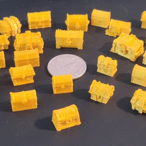 Puede incluir: Una colecci&oacute;n de 30 peque&ntilde;os cofres del tesoro de pl&aacute;stico amarillo. Los cofres son de diferentes formas y tama&ntilde;os, y algunos tienen detalles intrincados.