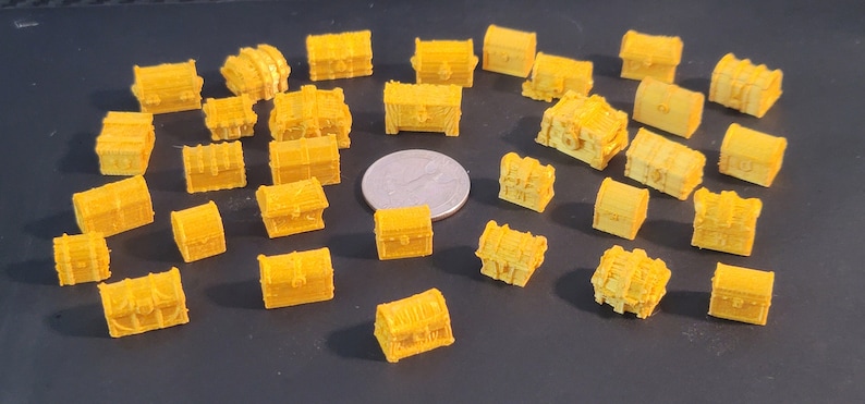 Puede incluir: Una colecci&oacute;n de 30 peque&ntilde;os cofres del tesoro de pl&aacute;stico amarillo. Los cofres son de diferentes formas y tama&ntilde;os, y algunos tienen detalles intrincados.