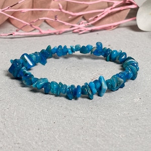 Op de afbeelding: Een blauwe armband van turquoise chips, gemaakt van kleine, onregelmatige stukjes turquoise. De armband is gemaakt van natuurlijke stenen en is een prachtig en uniek sieraad.