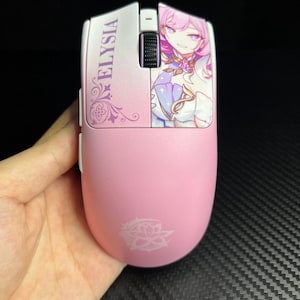 Puede incluir: Ratón de ordenador inalámbrico rosa con un diseño decorativo. El ratón presenta la palabra "ELYISIA" y una ilustración de personaje. Un logotipo blanco está en la parte inferior del ratón.