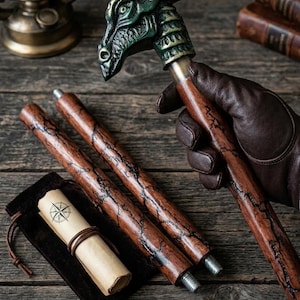 May include: A dragon-head walking cane with a green and bronze finish, alongside two spare wooden shafts. A rolled parchment with a compass rose design is in a small pouch. The cane and shafts have a dark wood grain.