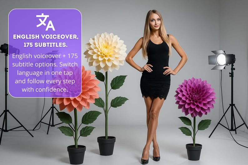 Pode incluir: Uma mulher de vestido preto est&aacute; perto de grandes flores de papel em vasos. As flores s&atilde;o p&ecirc;ssego, amarelas e roxas. A imagem inclui o texto "English voiceover, 175 subtitles."
