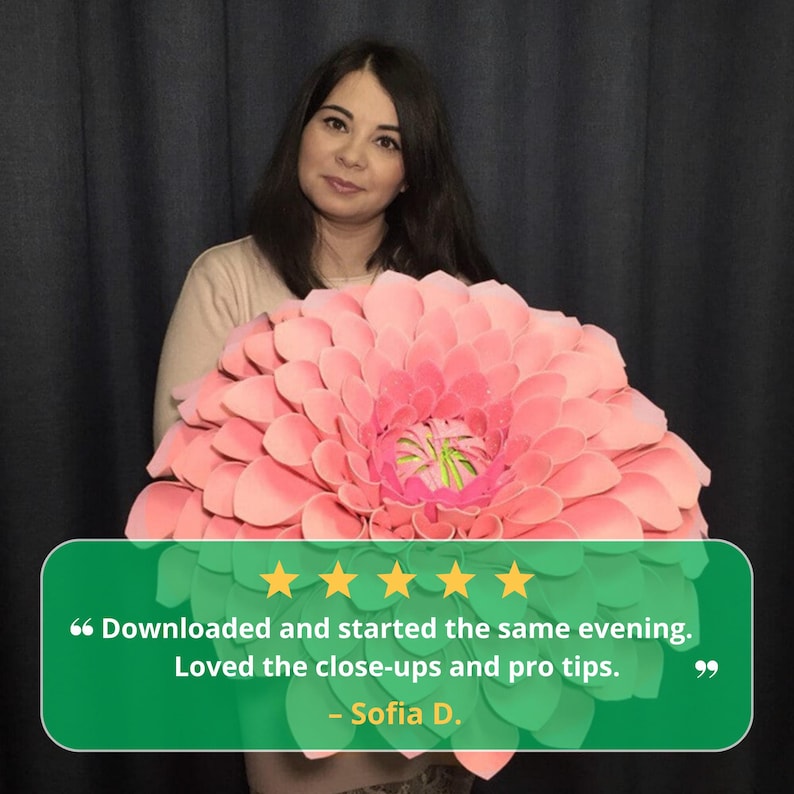 Pode incluir: Uma mulher segurando uma grande flor de papel rosa com um centro verde e amarelo. Uma faixa verde com cinco estrelas douradas e feedback do cliente est&aacute; na parte inferior da imagem.