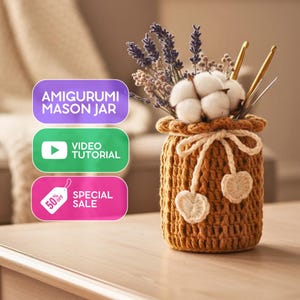 May include: A handmade, crocheted mason jar in brown, holding cotton bolls, lavender, and crochet hooks. The jar is decorated with a cream bow and heart-shaped details. The image includes text: "AMIGURUMI MASON JAR", "VIDEO TUTORIAL", and "SPECIAL SALE 50% OFF".