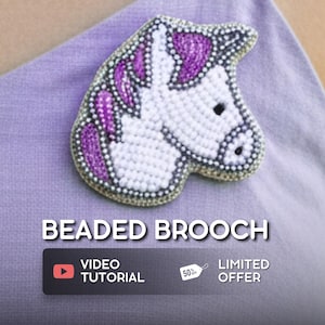 May include: A beaded unicorn head brooch. The brooch is made with white beads for the body, purple beads for the mane, and black beads for the eye and nostril. The text "BEADED BROOCH" is displayed below the brooch.