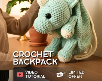 Peut inclure: Sac à dos en crochet fait main en forme de dragon, vert menthe et crème. Le sac à dos a un corps rond, de grands yeux noirs et une longue sangle crème. Le texte "CROCHET BACKPACK" et "VIDEO TUTORIAL" sont affichés.