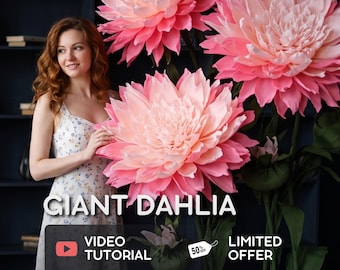 May include: Three oversized artificial dahlia flowers with layered pink and white petals on tall green stems. The text GIANT DAHLIA, VIDEO TUTORIAL, and LIMITED OFFER with a 50% off tag are displayed over the image of the large floral decorations.