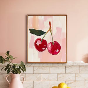 May include: A framed painting of two red cherries with a green leaf on a pink background.