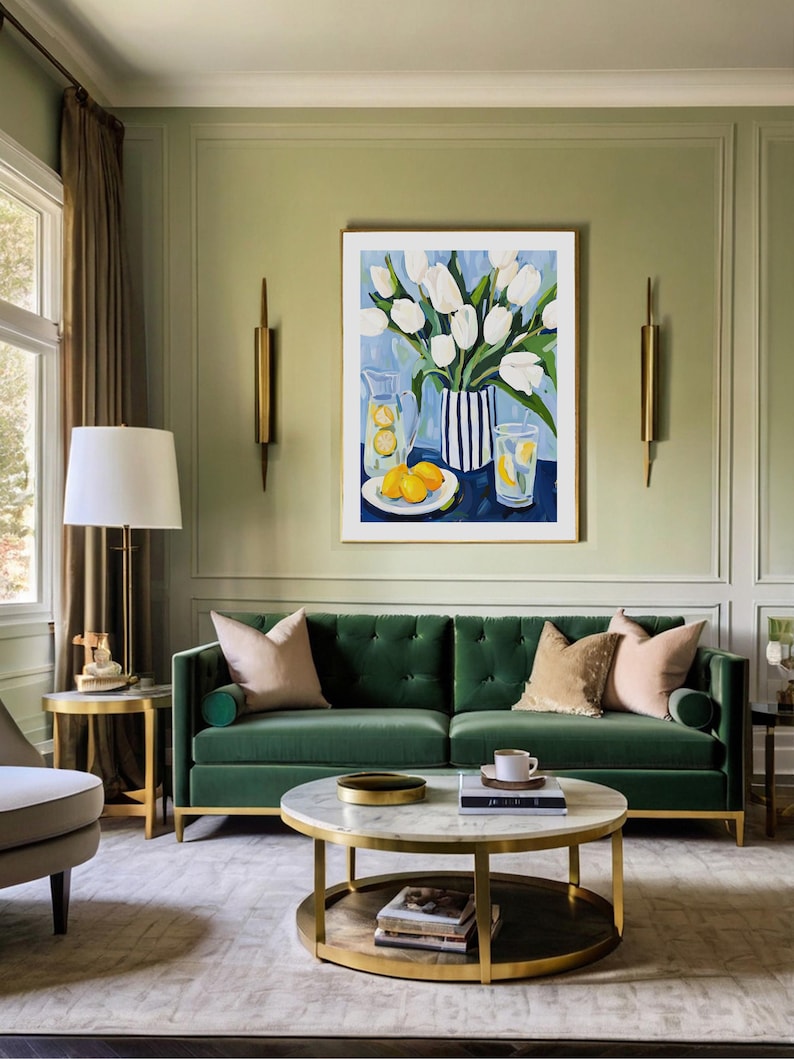 Puede incluir: Un sal&oacute;n elegante con un sof&aacute; de terciopelo verde y una mesa de centro con tapa de m&aacute;rmol. Una pintura enmarcada de tulipanes blancos y limones. La habitaci&oacute;n est&aacute; decorada con apliques dorados y una l&aacute;mpara de pie, creando un ambiente sofisticado.