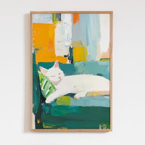 Può includere: Stampa artistica incorniciata raffigurante un gatto bianco che dorme su un divano turchese con un cuscino verde e bianco. Lo sfondo presenta pennellate astratte nei toni dell'arancione, del giallo e del blu. L'opera d'arte è in una cornice di legno.