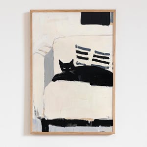 May include: Abstract art print featuring a black cat resting on a white sofa. The artwork has a minimalist style with a wooden frame. The cat is the focal point, with a simple yet striking design. The color palette includes black, white, and gray.