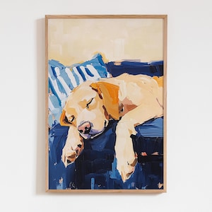 Może przedstawiać: Oprawiony wydruk przedstawiający śpiącego żółtego labradora. Pies jest namalowany zrelaksowany, spoczywający na niebieskiej powierzchni z pasiastą poduszką. Grafika ma jasną drewnianą ramę i miękki, malarski styl.