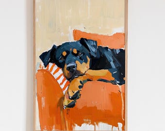 Puede incluir: Una pintura al óleo en un marco de madera clara que representa a un perro negro y fuego descansando en un sillón naranja. El perro tiene pelaje oscuro con marcas color fuego en la cara y las patas. El sillón tiene un cojín a rayas blancas y naranjas.