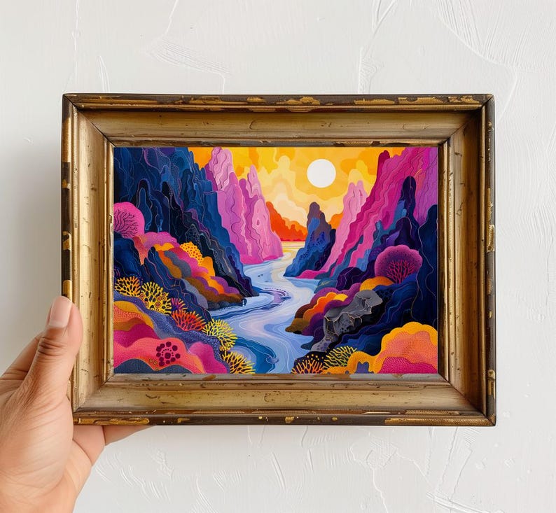 May include: A framed painting of a colorful landscape with a river winding through a canyon. The canyon walls are a mix of pink, purple, and blue, and the river is a vibrant blue. The sky is a bright yellow with a white sun.