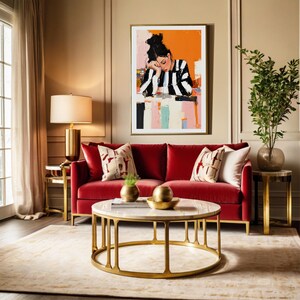May include: A red velvet sofa with gold legs and two throw pillows sits in front of a gold coffee table with a white marble top. A painting of a woman in a striped shirt hangs on the wall behind the sofa.