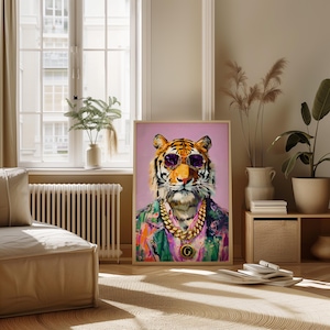 May include: A framed art print of a tiger wearing sunglasses and a gold chain. The tiger is depicted in a colourful shirt against a pink background. The artwork is displayed in a living room setting.