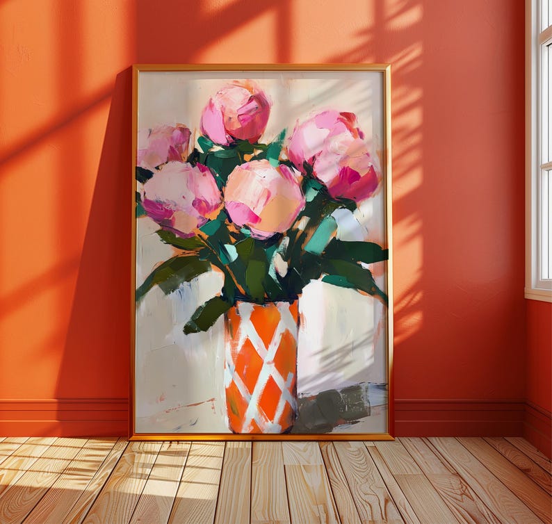 May include: A framed floral painting featuring a bouquet of pink peonies in a vase. The vase is orange with a white diamond pattern. The painting is set against a neutral background with green leaves.