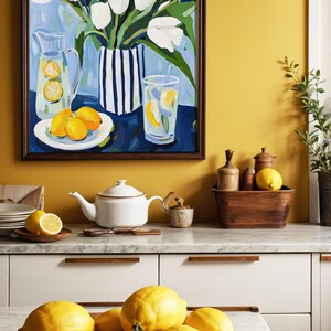 Puede incluir: Una pintura enmarcada de tulipanes blancos en un jarr&oacute;n a rayas, una jarra y un vaso de limonada con limones. Una tetera blanca, un cuenco de madera con limones y otros art&iacute;culos de cocina est&aacute;n sobre la encimera. La combinaci&oacute;n de colores es amarillo, blanco y azul.