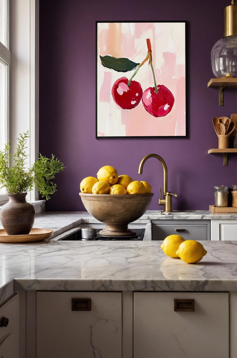 May include: A kitchen countertop with a white marble surface, a wooden bowl filled with lemons, and a gold faucet. A painting of two red cherries on a pink background hangs on the wall behind the bowl.