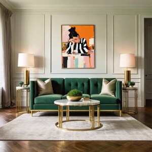 May include: A green velvet sofa with tufted buttons sits in a living room with a white marble coffee table and gold metal legs. Two gold lamps with white shades are on end tables with gold metal frames. A painting of a woman in a black and white striped shirt is hanging on the wall.