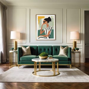 May include: A green velvet sofa with gold legs and two throw pillows sits in a living room with a gold coffee table and two gold side tables with lamps. A framed print of a woman wearing sunglasses and a striped shirt hangs on the wall.