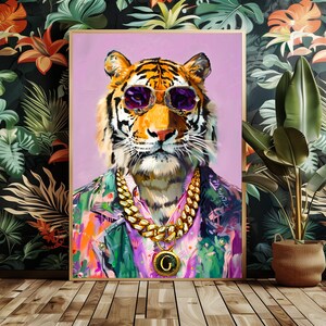 May include: A framed art print depicting a tiger wearing purple sunglasses, a gold chain necklace, and a vibrant shirt. The tiger's portrait is set against a light purple backdrop. The artwork is displayed on a wooden floor.