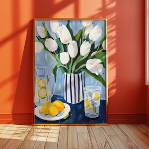 Puede incluir: Una pintura enmarcada representa una naturaleza muerta con tulipanes blancos en un jarr&oacute;n a rayas, una jarra y un vaso de limonada, y limones en un plato. El fondo es azul claro y el marco es dorado.
