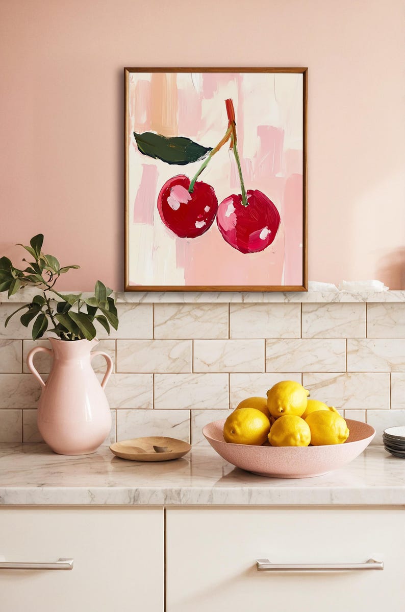 May include: A framed painting of two red cherries with a green leaf on a pink background.