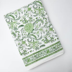 May include: White tablecloth with a green floral pattern. The pattern features a repeating design of leaves, flowers, and vines.