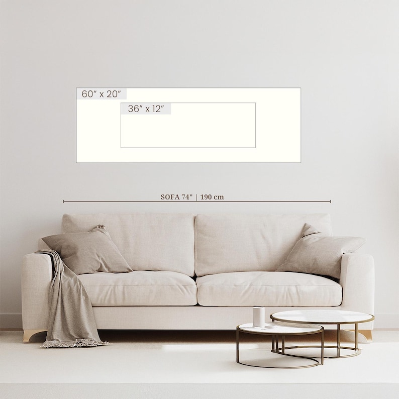 May include: A beige sofa with two cushions and a throw blanket. Two small round coffee tables with marble tops and metal frames are in front of the sofa. The sofa is 74 inches (190 cm) long. The image also shows a rectangular artwork with dimensions of 60" x 20" and 36" x 12".