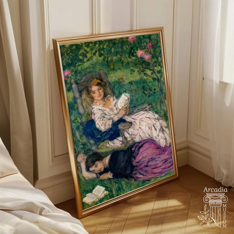 May include: A framed art print featuring an impressionist painting of two figures in a lush green garden. One figure sits in a chair reading a book, while the other lies on the grass nearby. The scene includes pink flowers and a book on the ground.
