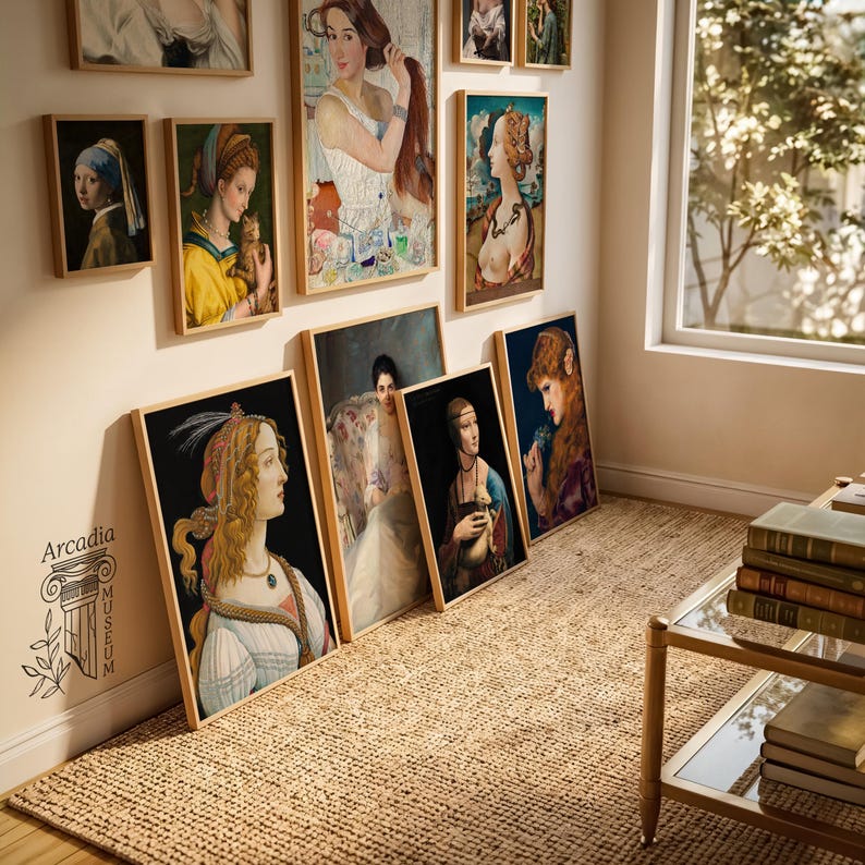 Puede incluir: Una colecci&oacute;n de l&aacute;minas de arte enmarcadas con varios retratos de mujeres, expuestas en una pared y apoyadas en el suelo. Las l&aacute;minas incluyen pinturas de estilo cl&aacute;sico con diversas paletas de colores y el texto Arcadia Museum visible en la pared.