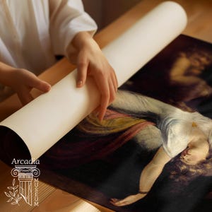 May include: A rolled canvas print featuring a classical oil painting of a figure in a white garment with red and gold accents. The print is partially unrolled, revealing a dark background. The text Arcadia Museum is printed in white at the bottom.