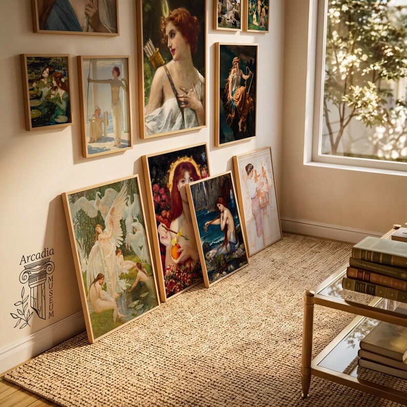 May include: A collection of framed art prints featuring classical paintings of figures and mythological scenes displayed on a wall and floor. The text Arcadia Museum is printed on the wall. A glass table with stacked books sits nearby.