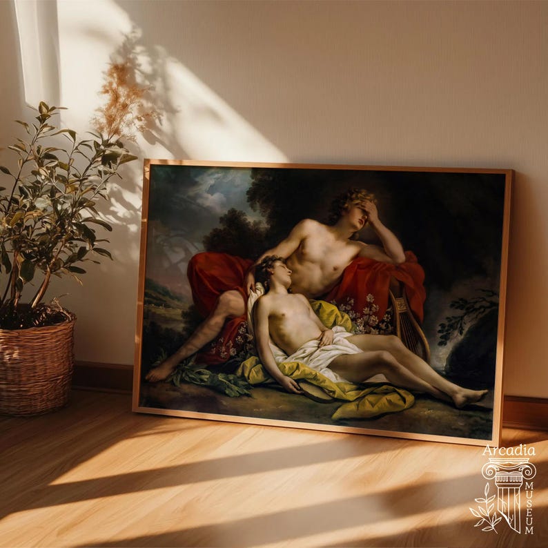 May include: A framed rectangular art print featuring a classical oil painting of two figures resting in a landscape. One figure reclines with a hand to their forehead, while the other lies below draped in white and yellow fabric against red cloth.