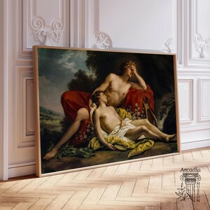 May include: A rectangular framed print featuring a classical oil painting of two figures resting in a landscape. One figure reclines with a hand to their forehead, draped in red fabric, while the other lies below in white and yellow cloth.