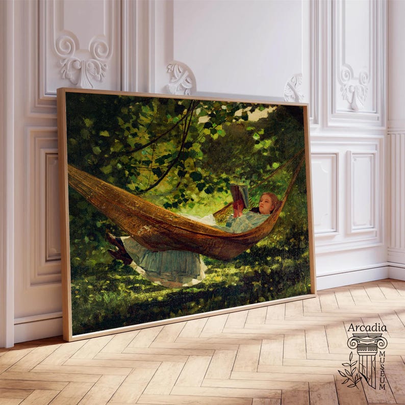 May include: A rectangular framed art print depicting a person in a light-coloured dress reclining in a brown hammock suspended among lush green trees, reading a book. The scene is set in a shaded outdoor environment with dappled sunlight.