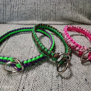 May include: Three paracord dog collars in green, brown, and pink with silver metal D-rings.