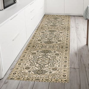 May include: A beige and brown patterned runner rug with a geometric design. The rug is placed in a kitchen with white cabinets and a wood floor.