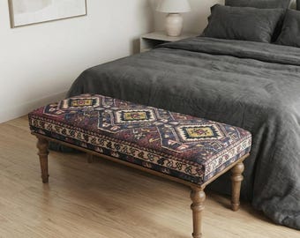 Divano d'accento in stile Kilim, pouf imbottito con rivestimento in tessuto e gambe in legno tornito.