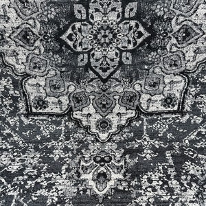 May include: A black and white rug with a traditional Persian design. The rug has a central medallion and intricate floral patterns.