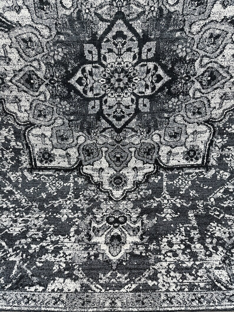 May include: A black and white rug with a traditional Persian design. The rug has a central medallion and intricate floral patterns.
