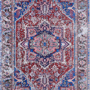 K&ouml;nnte beinhalten: Ein Vintage-Teppich mit einem abgenutzten, verblassten Look. Der Teppich hat ein zentrales Medaillon mit komplizierten geometrischen Mustern in Rosa-, Blau- und Gr&uuml;nt&ouml;nen. Der Rand des Teppichs ist dunkelblau mit einem sich wiederholenden Muster aus floralen Motiven.