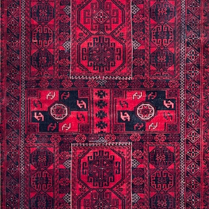 May include: A rectangular, hand-woven rug with a rich red background and intricate black geometric patterns. The design features repeating motifs and a detailed border, showcasing traditional craftsmanship. The rug's texture suggests a durable, high-quality material.