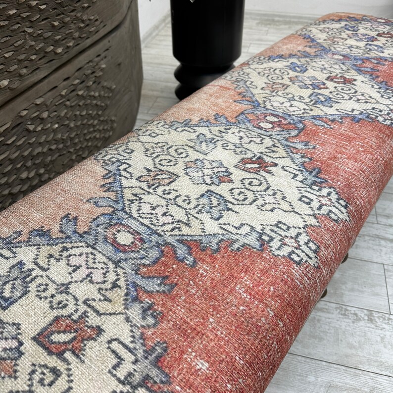 May include: A red, white, and blue patterned bench with a woven fabric top. The bench is made of wood and has a rustic look.