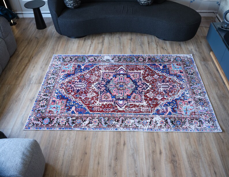 K&ouml;nnte beinhalten: Ein bunter Teppich mit traditionellem persischem Design in Rot-, Blau-, Rosa- und Wei&szlig;t&ouml;nen. Der Teppich hat ein zentrales Medaillon und komplizierte Blumenmuster.